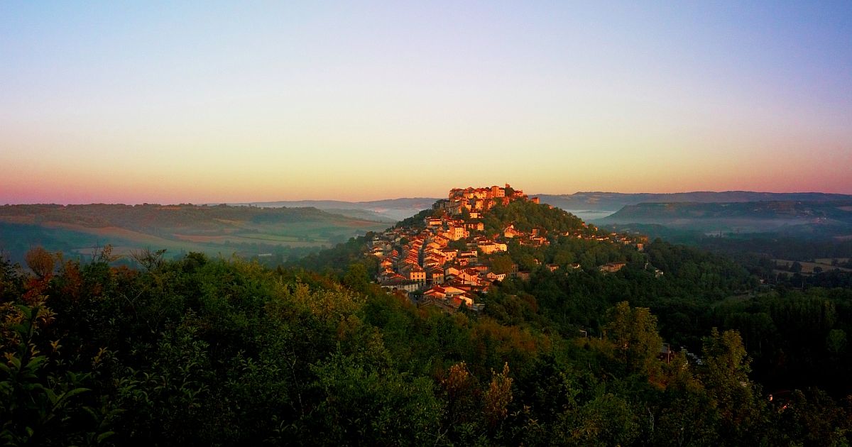 hilltop village surrounded by forest at dawn