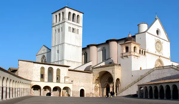 Large, white Basilica chruch undre a clear blue sky in italy's Umbria.