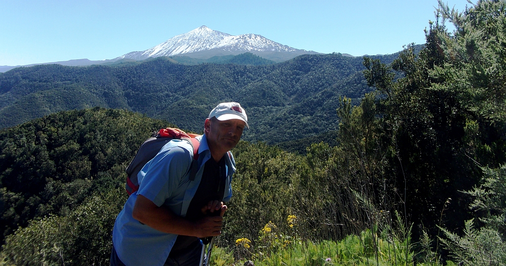 The guide for this walking holiday posing for a photo, snowy peak and green forests in the background