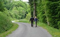 Two people walking along a road in the Dordogne