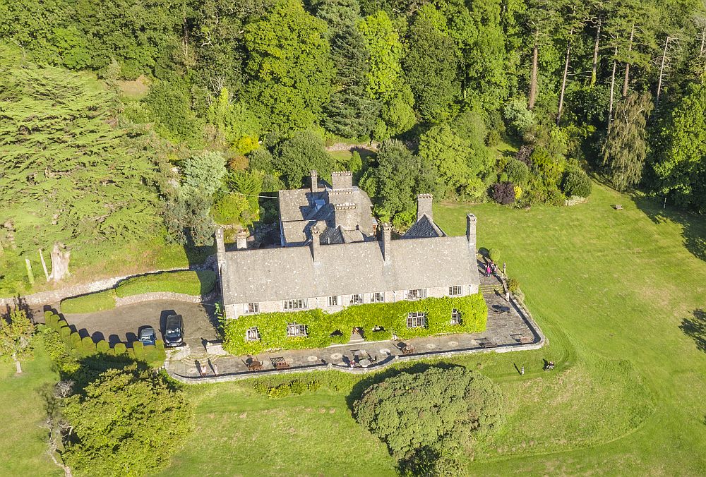 Aerial view of a big house among trees and meadows