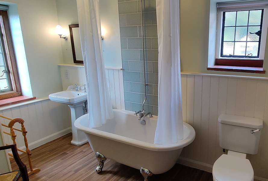 Big bathroom with a bathtub, toiilet and a sink