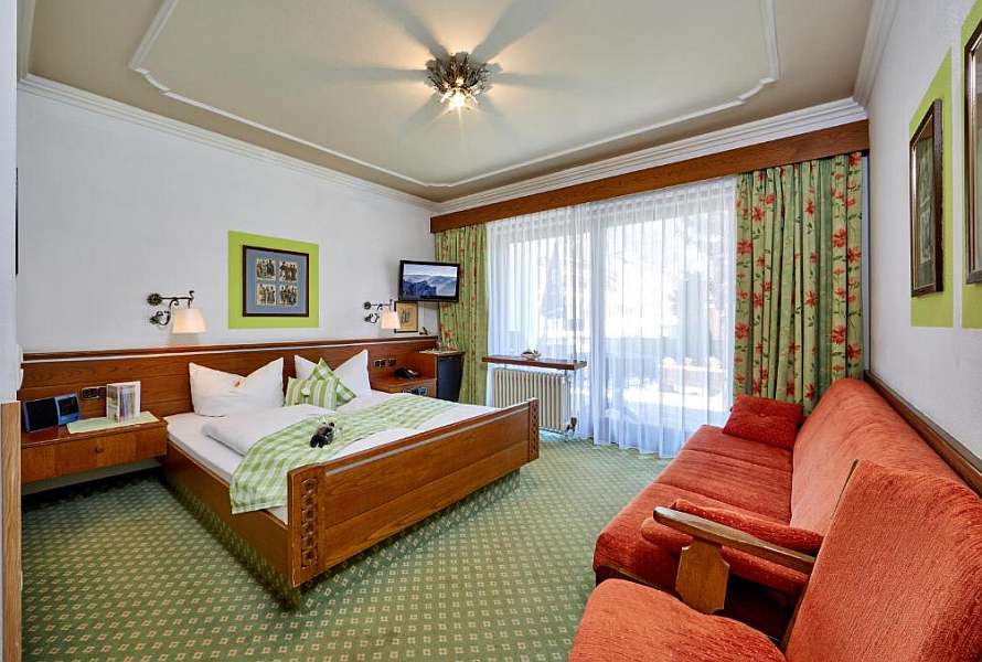 Spacious bedroom with king bed and a sofa