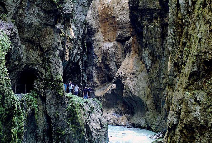 Two hikers in a gorge admiring the thundering waters below
