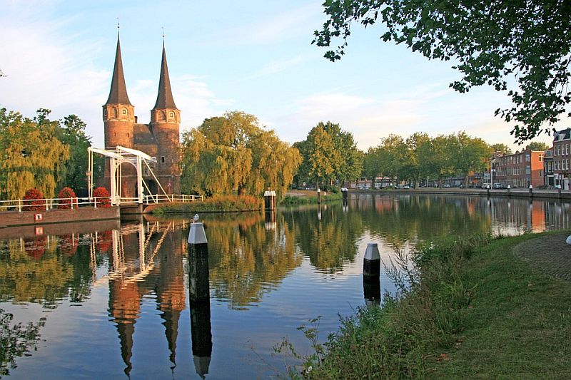 Canal with small bridge and towers in Delft