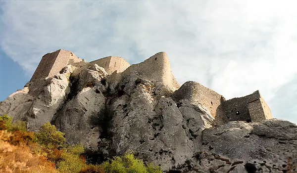 Old castle ruins at the top of steep, rocky cliffs