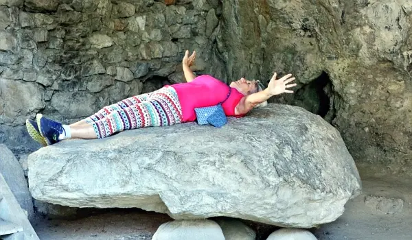 female hiker lying on a large rock