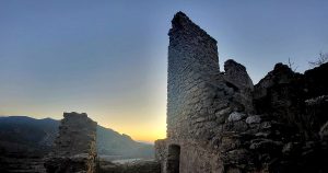 Sun rising behind the ruins of a castle